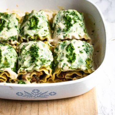 Vegan White Mushroom Lasagna Rolls with meaty sauteed mushrooms, flavor-packed pesto, smoky walnut sausage, and a dreamy roasted garlic sauce. They can be made ahead of time and are perfect for date-night-in! #vegan #mushrooms #lasagna #veganlasagna #plantpowercouple #pesto #walnuts #tofu #pasta #veganpasta // plantpowercouple.com