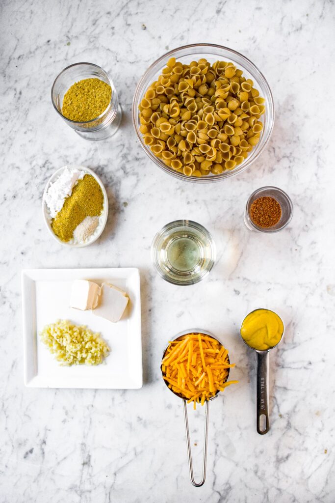 Overhead view of all the ingredients you need to make this Daiya mac and cheese recipe laid out on a grey marble coutnertop