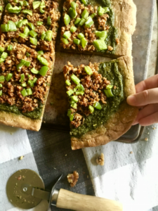 This vegan pizza is THE BEST! Rustic wheat crust, flavorful pesto, and smoky walnut sausage. It's easy to make and VERY fun to eat! // Recipe from plantpowercouple.com