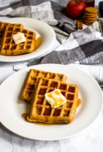These vegan apple cider waffles with ginger snap syrup are a fun fall breakfast recipe without any butter, milk, or eggs! It’s an easy way to use up extra apple cider and apple sauce. Plus, they can even be made into apple cider pancakes if you don’t have a waffle maker. Store them in the freezer and reheat them in the toaster for easy comfort food breakfast or snack on the go. #applecider #applerecipe #waffles #veganwaffles #fallbreakfast #veganbreakfast #dairyfreebreakfast