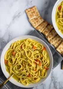 This vegan chicken noodle soup is the stuff of our childhood sick day dreams! Warm + cozy broth bursting with flavor, thick brothy noodles, tender chicken-free chicken. Easy, soothing, gluten-free option. #vegan #soup #plantbased #veganrecipe // plantpowercouple.com