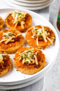 These Polenta Pizza Bites are a delicious and easy appetizer or snack for a potluck or holiday gathering. They are everything you love about pizza but with a crispy polenta crust. The recipe is plant based, dairy free, egg free, and include a simple gluten free option as well. These easy mini pizzas are the perfect vegan party food for kids and adults alike!