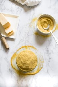 This easy 6-ingredient vegan cheese seasoning is a staple in our kitchen! Use it as a dairy-free parmesan on pasta, a cheesy popcorn seasoning, and mix it with vegan butter to make the BEST dairy-free garlic bread. It can also be used to make an easy cheesy pasta sauce! #vegan #vegancheese #veganseasoning #dairyfree #plantbased #nutritionalyeast #veganpopcorn