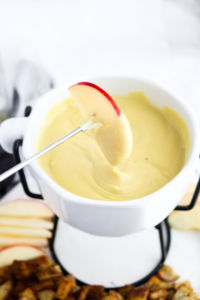 This vegan Irish cheddar + whiskey fondue recipe has a creamy cashew + white bean base with a gooey stretchy texture and the most wonderful tangy zip! Easy to make and great for St. Patrick's Day! #vegan #fondue #dairyfree #whiskey // plantpowercouple.com