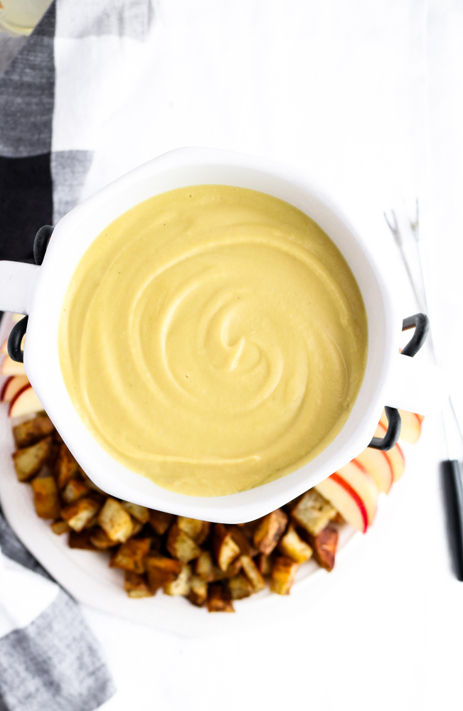This vegan Irish cheddar + whiskey fondue recipe has a creamy cashew + white bean base with a gooey stretchy texture and the most wonderful tangy zip! Easy to make and great for St. Patrick's Day! #vegan #fondue #dairyfree #whiskey // plantpowercouple.com
