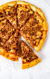 This Vegan Baked Ziti Pizza is like a delicious dream: Saucy ziti, flavorful walnut sausage, and an ooey gooey dairy-free mozzarella sauce on a fluffy pizza crust baked to perfection in your cast iron pan. Basically, this meat-free comfort food dish is everything you love about a classic baked ziti but veganized and on a PIZZA! This fun vegetarian dinner recipe is shockingly easy and will be your favorite plant-based pizza to make with your partner, friends, or kids!