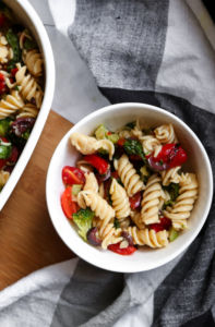 This simple vegan pasta salad recipe is a “grown-up-riff” off the traditional side dish my Gram used to make for me at ALL the family BBQs + parties. It’s quick, easy to make and bursting with flavors of fresh veggies like red peppers, tomatoes, kalamata olives, and more! #vegan #plantbased #recipe #summer #sidedish // plantpowercouple.com