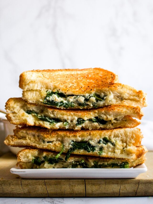 This vegan feta grilled cheese with spinach is our fun take on a classic grilled cheese and pairs perfectly with tomato soup. The easy recipe uses either our homemade tofu feta or one of the many store-bought vegan fetas now available. It will impress the pants off your next lunch guests! #vegan #vegancheese #veganfeta #vegangrilledcheese #dairyfree #grilledcheese #veganlunch #veganrecipe #easyveganrecipe #vegandinner #vegansandwich