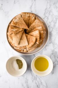 Make your own pita chips in the air fryer with just 4 ingredients and 20 minutes of your time! Perfect for snacking or dipping in hummus.
