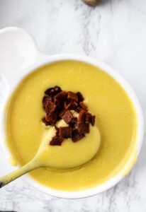 This creamy vegan potato soup recipe is easy to make right in your Vitamix or other high-powered blender! It’s the BEST dairy-free potato soup we’ve ever eaten - loaded with flavor, a thick creamy texture, and soul-warming from start to end. Load it with your favorite toppings like vegan bacon and cheese or sip it out of a mug on a cold winter day!