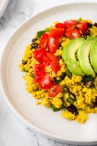 This vegan tofu scramble recipe infused with Southwest flavors is a healthy and delicious plant-based breakfast option! It’s an egg-free breakfast scramble made with black salt for that unique eggy flavor as well as a wonderful array of common household spices. We love to serve this as a breakfast platter or burrito and even sometimes make a big batch to have breakfast for dinner!