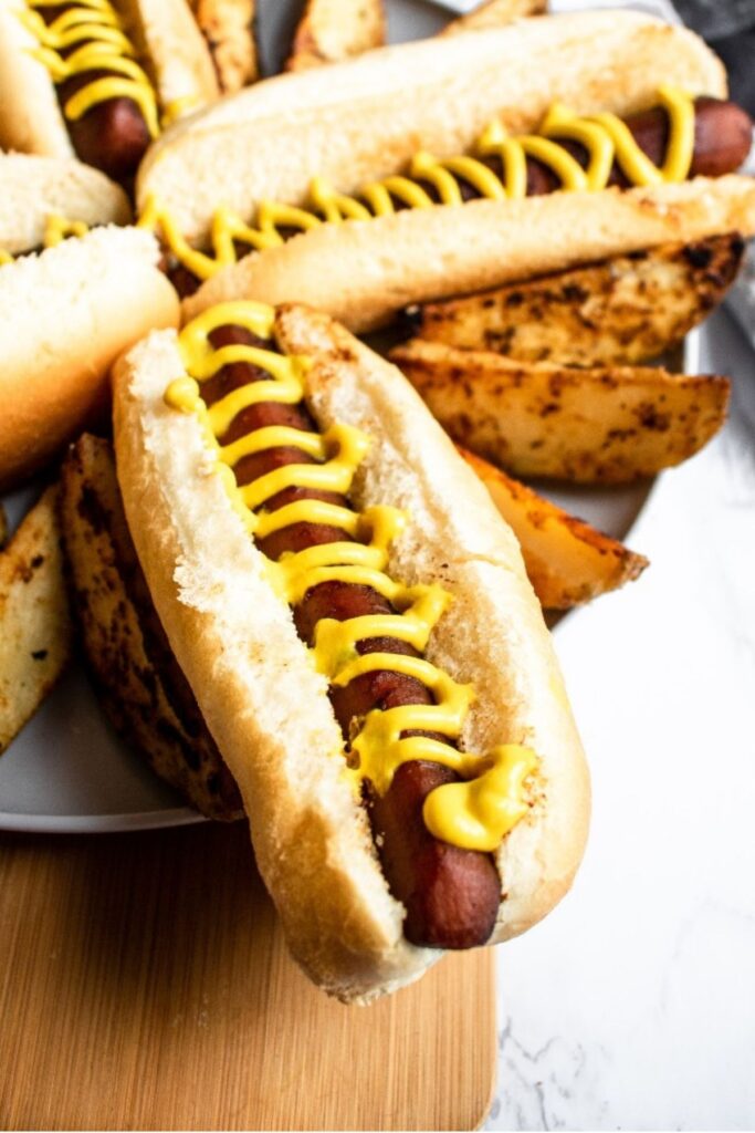 Overhead view of a carrot hot dog in a bun topped with a squiggle of mustard