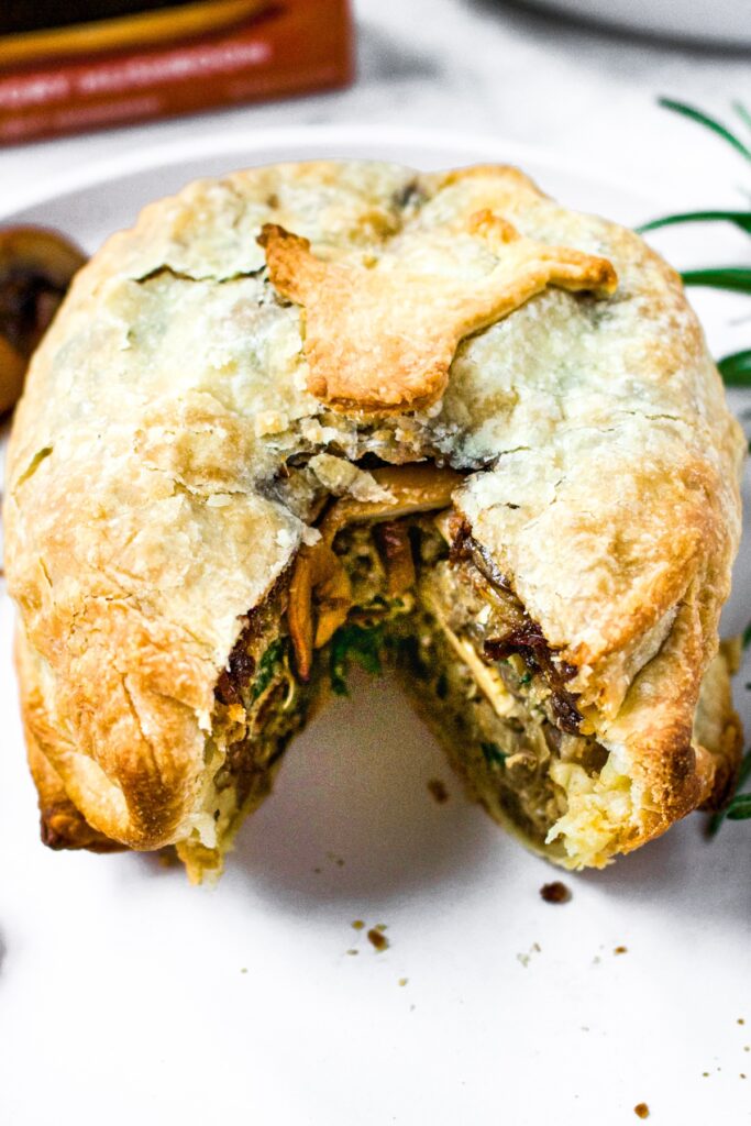 Close-up shot of a vegetable burger wellington with a slice taken out of it, so you can see the inside