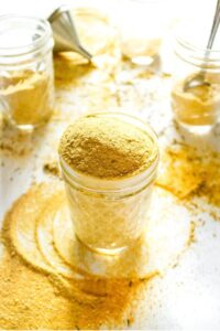 Overhead view of a clear glass jar overflowing with vegan chicken bouillon powder