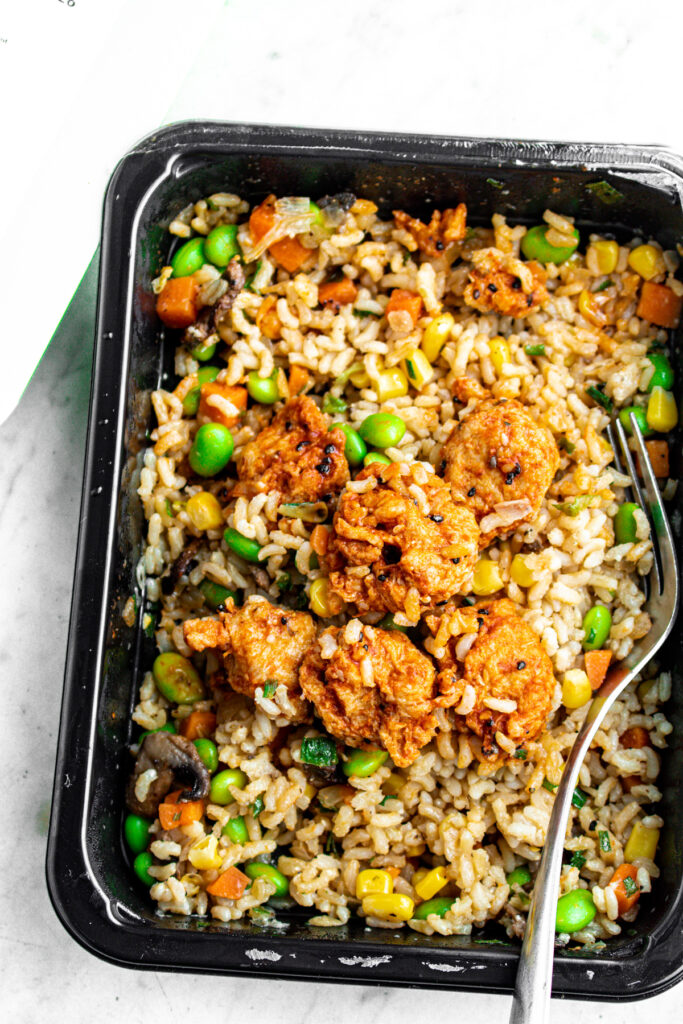 Overhead view of a Purple Carrot ready to eat meal with fried rice and vegan Korean chicken