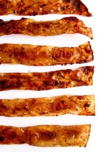 Overhead close up view of slices of rice paper bacon lying flat on a white background