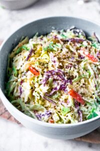 Head on photo of a large mixing bowl filled with plant-based coleslaw