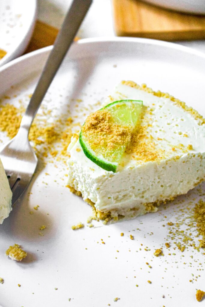 Close up overhead photo of a slice of dairy free key lime pie with a bite taken out of it.