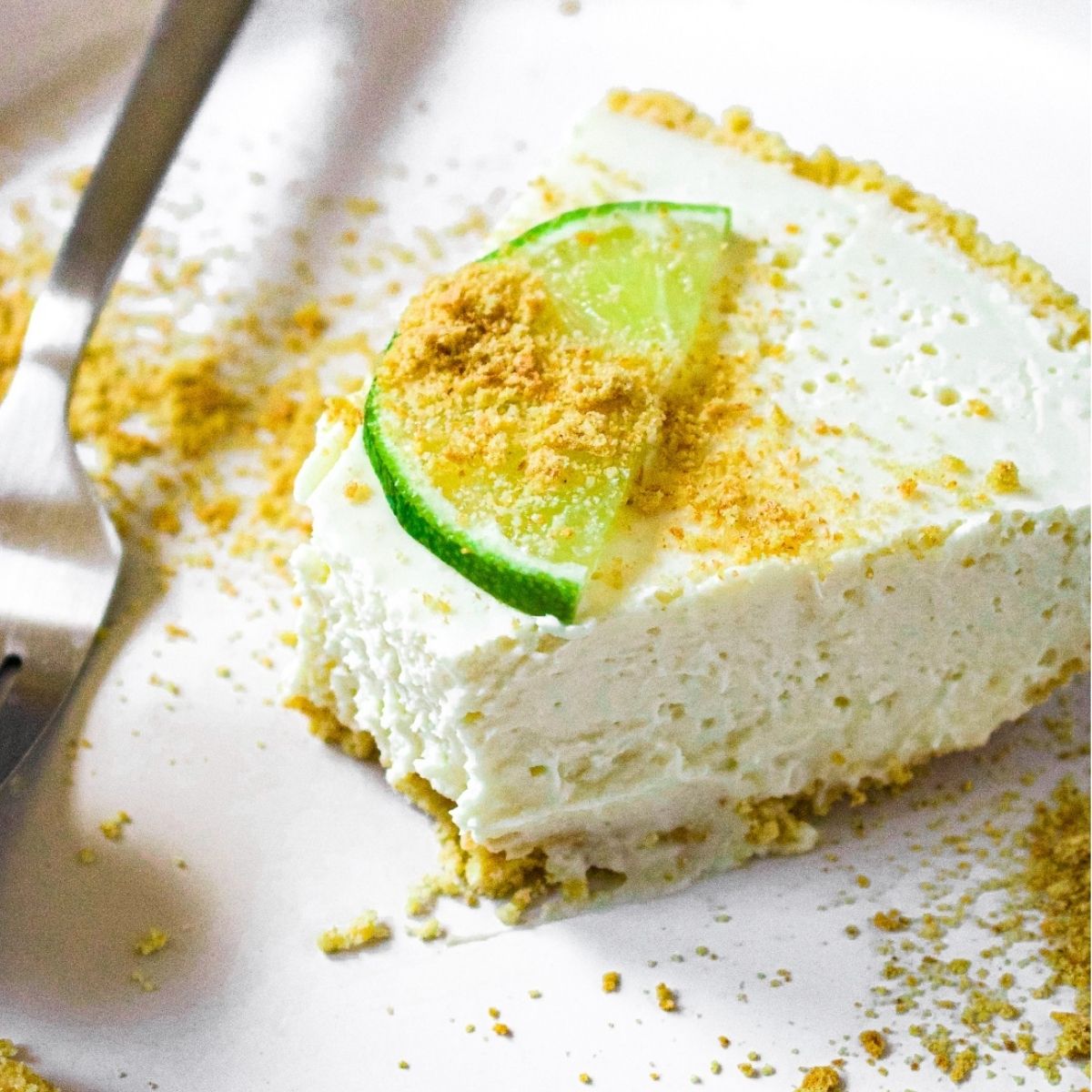 Close up overhead photo of a slice of dairy free key lime pie with a bite taken out of it.