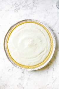Dairy free key lime pie filling in a vegan graham cracker crust before it chills in the fridge