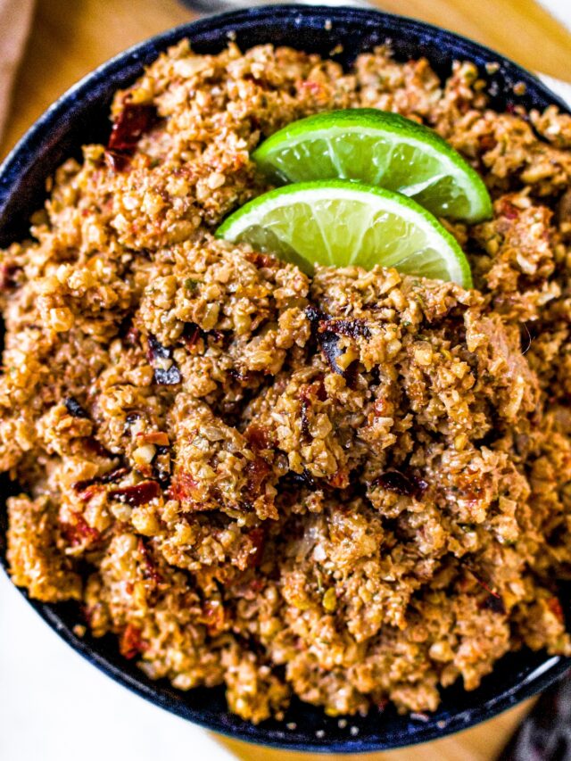 Close up overhead shot of a bowl of vegan ground chorizo with two lime wedges on top