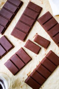 Overhead shot of homemade chocolate bars, some broken into rectangular pieces.