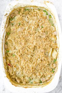 Overhead shot of a white rectangular casserole dish with a bread crumb topped vegan tuna casserole in it before the crumbs are browned