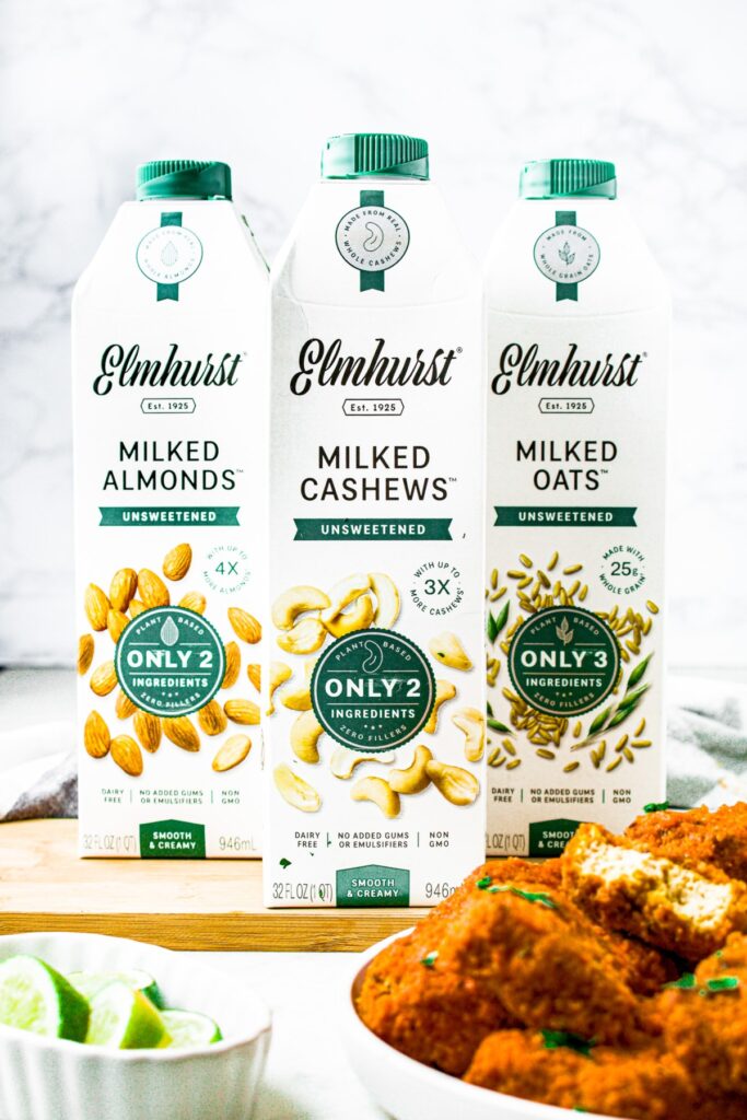 Head on shot of 3 cartons of Elmhurst unsweetened milks: almond milk, cashew milk, and oat milk.