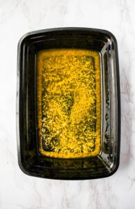 Overhead shot of a black rectangular container with a lemon pepper marinade filling the bottom of it.