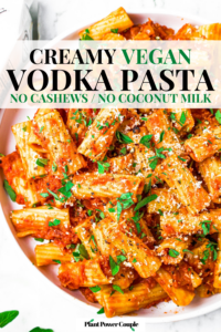 Overhead close up shot of a plate of vegan vodka cream pasta sprinkled with fresh Italian herbs. Text reads: creamy vegan vodka pasta, no cashews, no coconut milk
