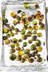 Overhead shot of a foil lined baking sheet with oven-roasted brussel sprouts