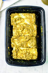Overhead shot of vegan pesto chicen marinating in a rectangular black container