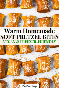 Close up overhead shot of a batch of homemade vegan soft pretzel bites on a parchment-lined baking sheet. Text reads: warm homemade soft pretzel bites, vegan & freezer-friendly
