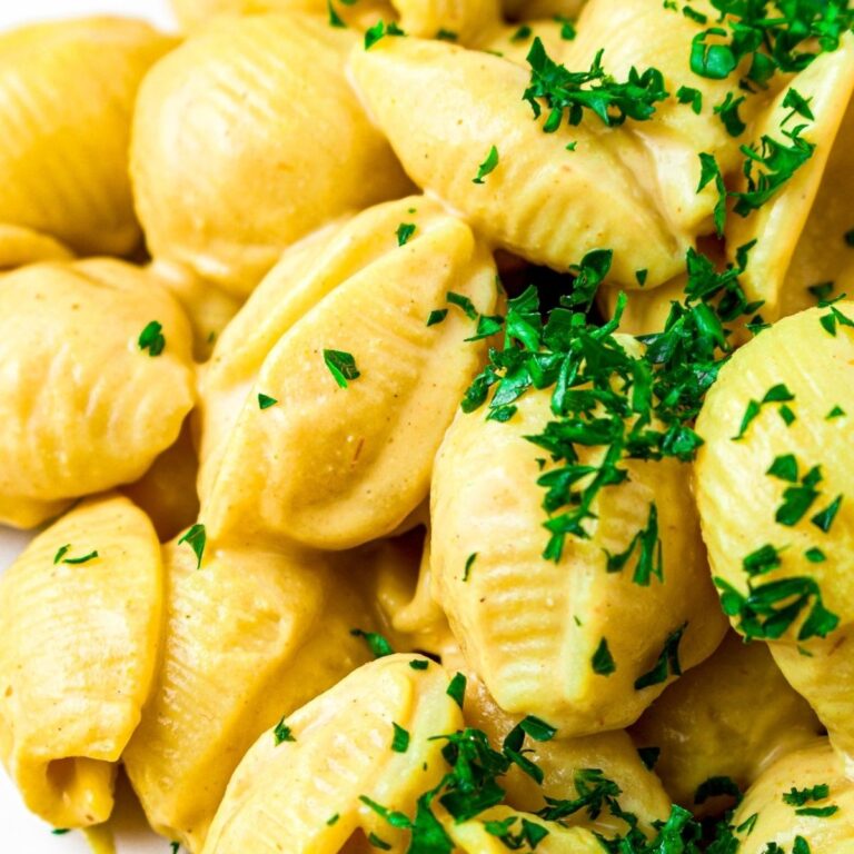 Overhead close up view of creamy vegan silken tofu mac and cheese sprinkled with fresh minced parsley