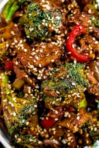 Close up overhead shot of a plate of vegan beef and broccoli sprinkled with sesame seeds
