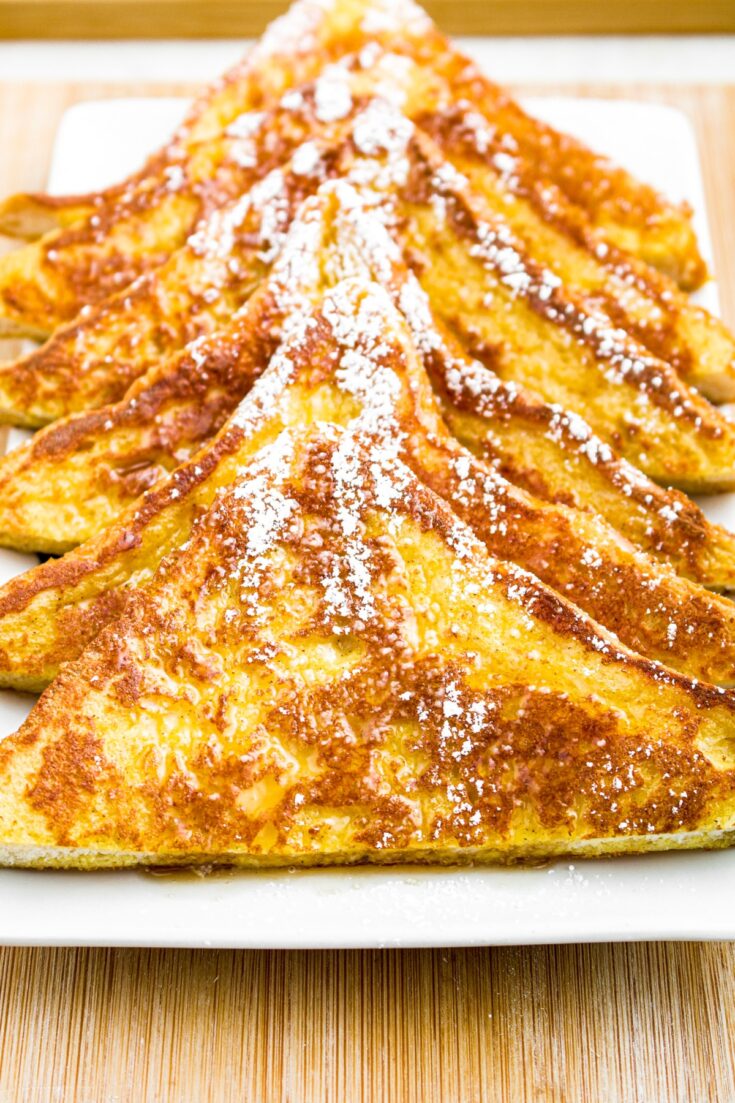 Close up overhead photo of a plate of vegan French toast with powdered sugar sprinkled on top