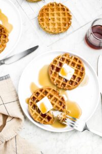 Overhead photo of a plate with two vegan protein waffles and a fork digging into one of them
