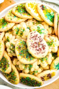 Zoomed in overhead photo of a vegan cookie plate with dairy-free spritz cookies decorated for spring holidays