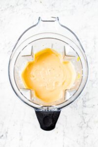 overhead photo of an open Vitamix blender with freshly blended vegan cheese sauce in it