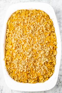 overhead photo of a rectangular casserole dish with breadcrumb topped vegan mac and cheese casserole before baking