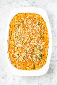 overhead photo of a casserole dish of baked vegan mac and cheese casserole