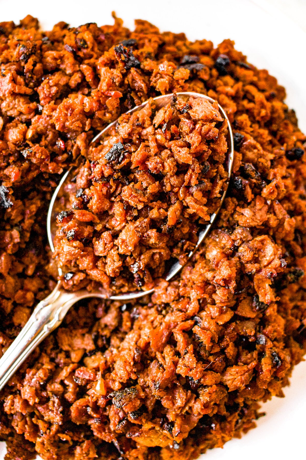Close up overhead photo of a pile of vegetarian ground beef with a spoon digging into it