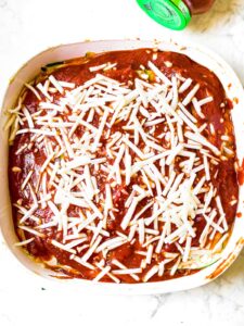 Overhead photo of a square baking dish filled with vegan low carb lasagna topped with dairy-free mozzarella cheese
