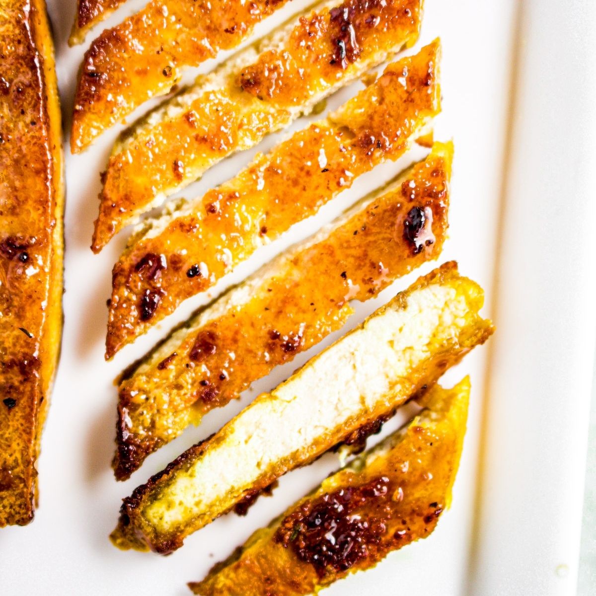 Overhead photo of a sliced pineapple teriyaki tofu cutlet on a plate