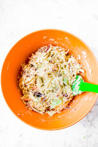 Overhead photo of a large bowl of healthy coleslaw with a rubber spatula sticking into it