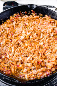 Overhead photo of a cast iron pan with shredded vegan pork cooking in it