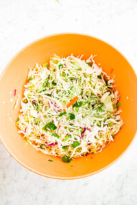 Overhead photo of a mixing bowl filled with coleslaw salad without the dressing