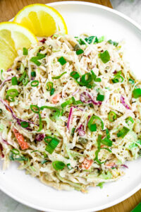 Overhead close up photo of peppery lemon tahini coleslaw garnished with ground black pepper