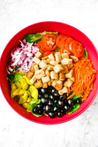 Overhead photo of a large mixing bowl with all the ingredients you need to make olive garden house salad