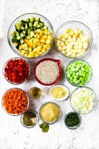 Overhead photo of all the ingredients you need to make a vegan vegetable barley soup with zucchini and summer squash